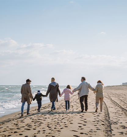 Familia caminando por la playa agarrados de las manos