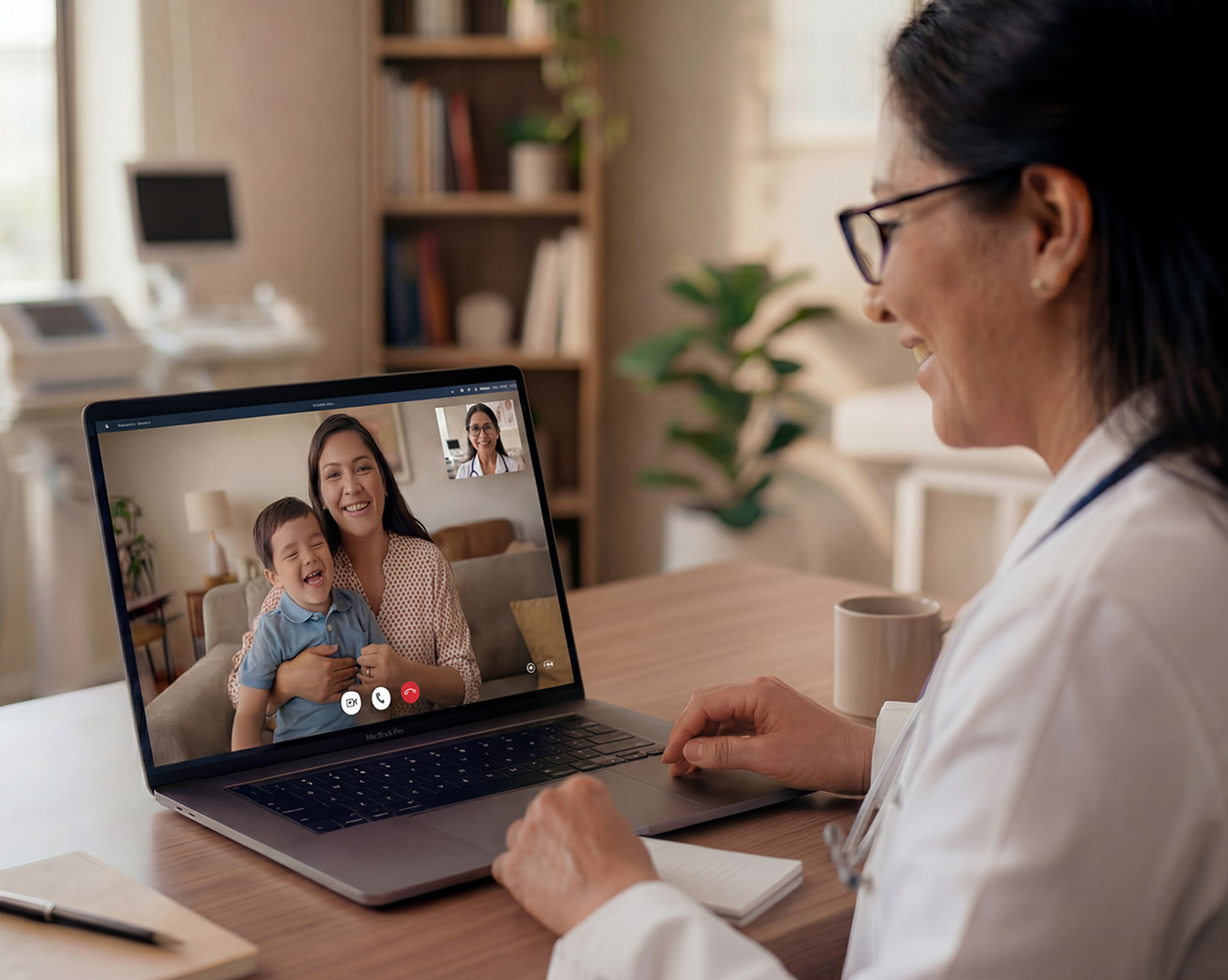 Doctora en consulta virtual con un niño y su mamá.