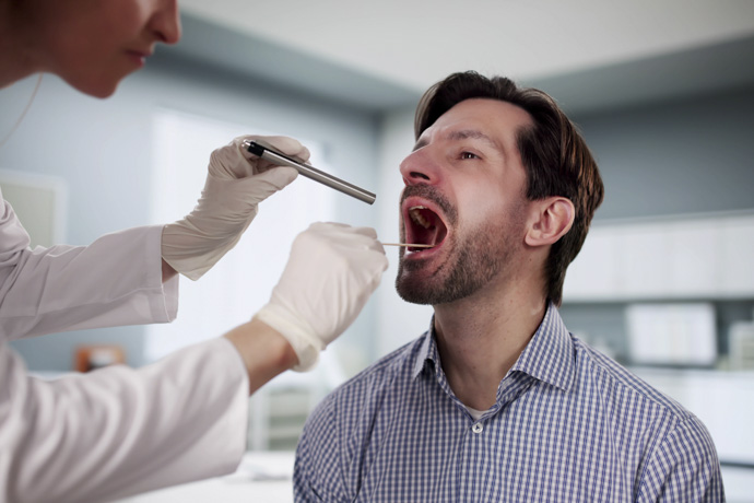 Médico revisa malestar en lengua y boca 