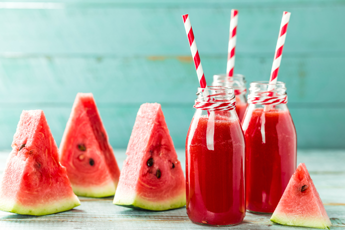 Pedazos dee sandía y vasos con su jugo