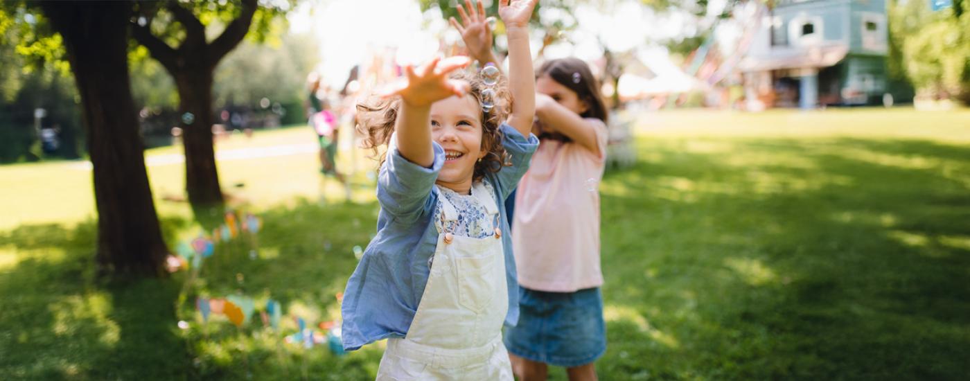 Niñas jugando con burbujas en el parque