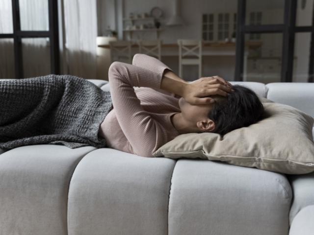 Mujer en Ecuador recostada en un sofá, ilustrando las consecuencias de no dormir bien