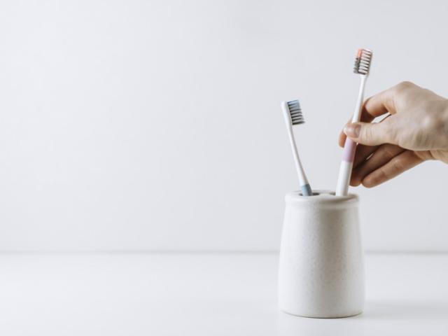 Persona sostiene cepillo de dientes
