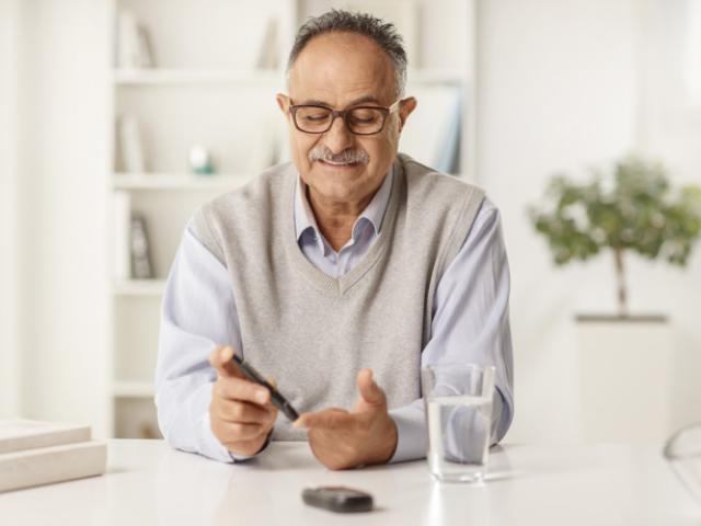Hombre con diabetes revisa sus niveles de glucosa