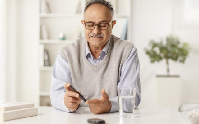 Hombre con diabetes revisa sus niveles de glucosa
