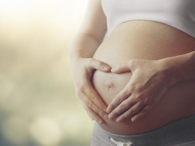 Mujer embarazada sujetando su vientre con las manos por molestias digestivas y diarrea durante el embarazo 