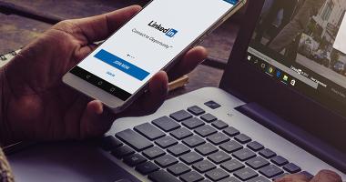 Persona viendo su celular con la app de Linkedin